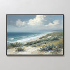 The Ocean Bluff Canvas Art - Horizontal features a coastal scene with sandy dunes, sparse vegetation, rolling waves, and a cloudy blue sky above the ocean shore in a framed canvas print.