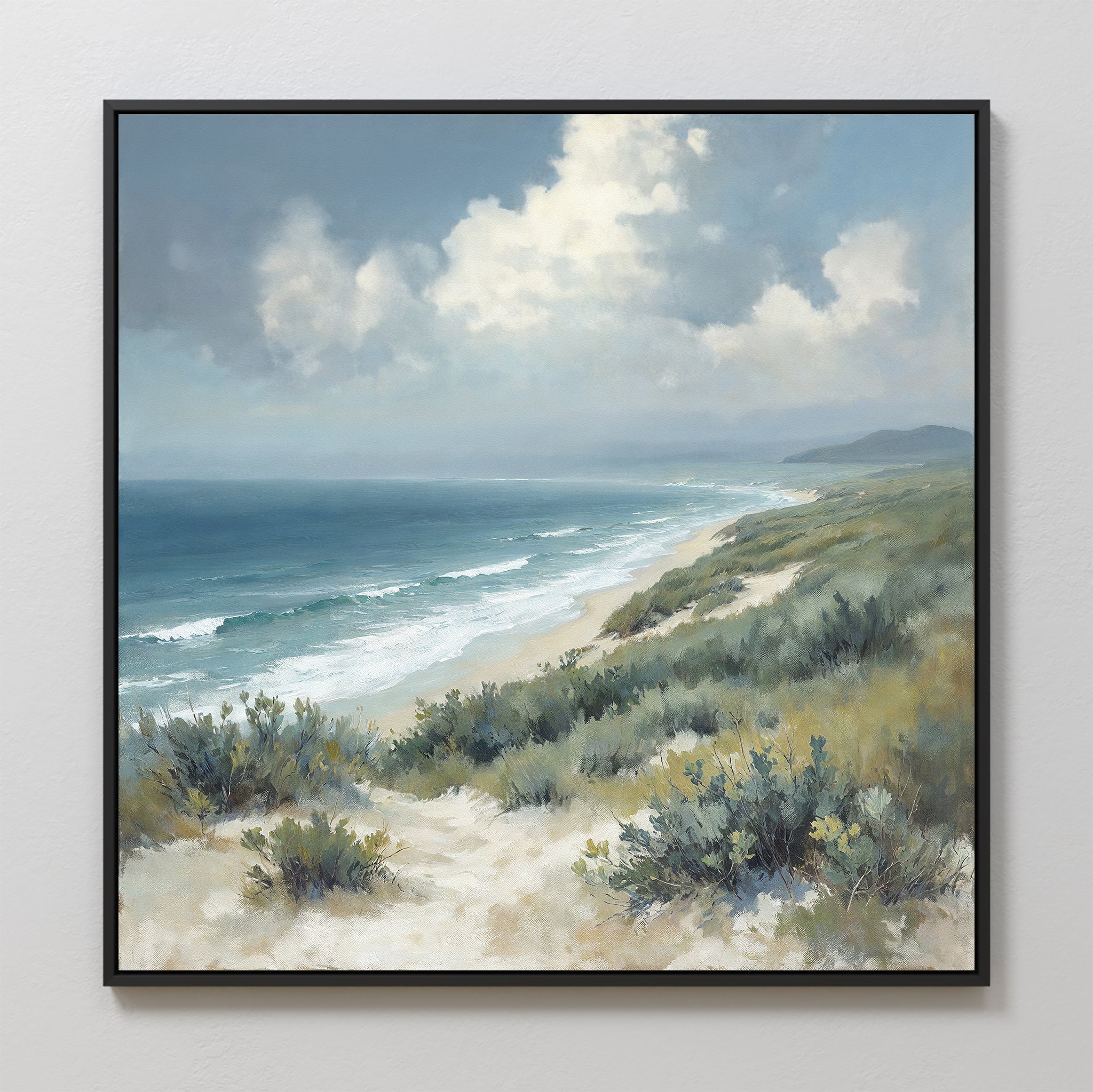 The Ocean Bluff Canvas Art - Square features sandy dunes, green shrubs, gentle ocean waves, distant hills, and a cloudy blue sky—ideal for bringing serene coastal vibes to your space.
