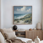 A cozy living room with neutral tones features a sofa with beige cushions, a wooden sideboard adorned with decor, and the Ocean Bluff Canvas Art - Square displayed on the wall.
