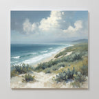 Ocean Bluff Canvas Art - Square features a serene seaside scene with a sandy beach, gentle waves, lush greenery, and a partly cloudy sky—perfect for adding coastal tranquility to your space.