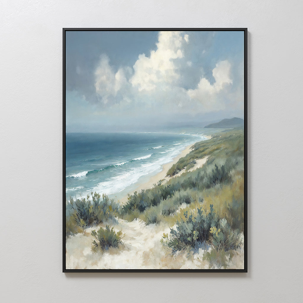 The Ocean Bluff Canvas Art - Vertical features sandy dunes and green shrubs in the foreground, waves on a blue ocean, and a cloudy sky above with faint distant mountains, creating serene coastal wall art.