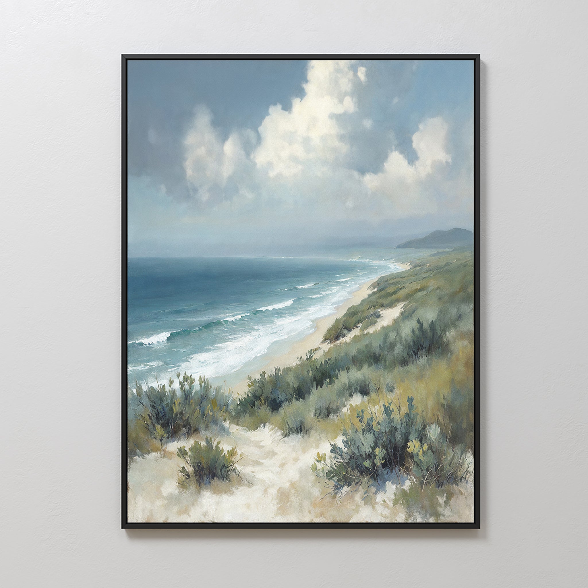 The Ocean Bluff Canvas Art - Vertical features sandy dunes and green shrubs in the foreground, waves on a blue ocean, and a cloudy sky above with faint distant mountains, creating serene coastal wall art.