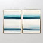 The Ocean Motion - Set Of 2 features abstract prints with horizontal blue, teal, and white bands in gold frames, adding serene sophistication and a coastal decor style to any plain white wall.