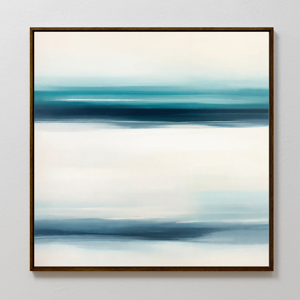 Ocean Motion Canvas Art - Square features an abstract print in a dark frame with softly blended horizontal bands of blue, teal, and white, evoking serene sophistication and a minimalist seascape against a light background.