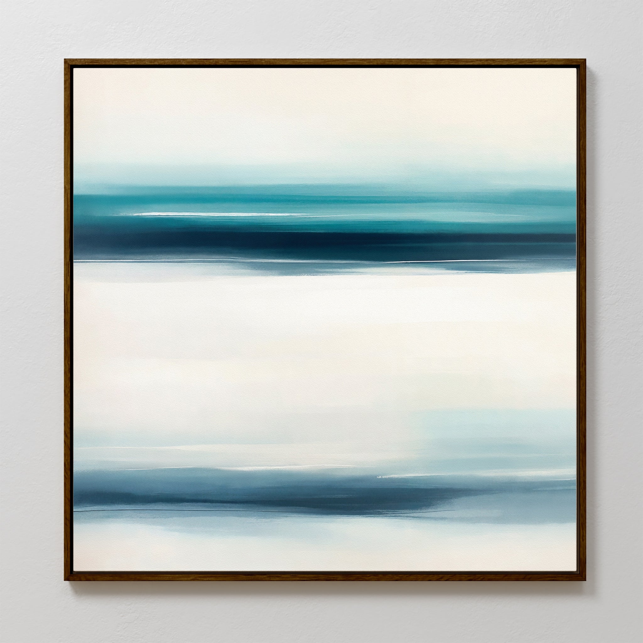 Ocean Motion Canvas Art - Square features an abstract print in a dark frame with softly blended horizontal bands of blue, teal, and white, evoking serene sophistication and a minimalist seascape against a light background.