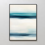 The Ocean Motion Canvas Art - Vertical features softly blended blue, teal, and white streaks. Framed in black and displayed on a light wall, it adds serene sophistication ideal for coastal decor.