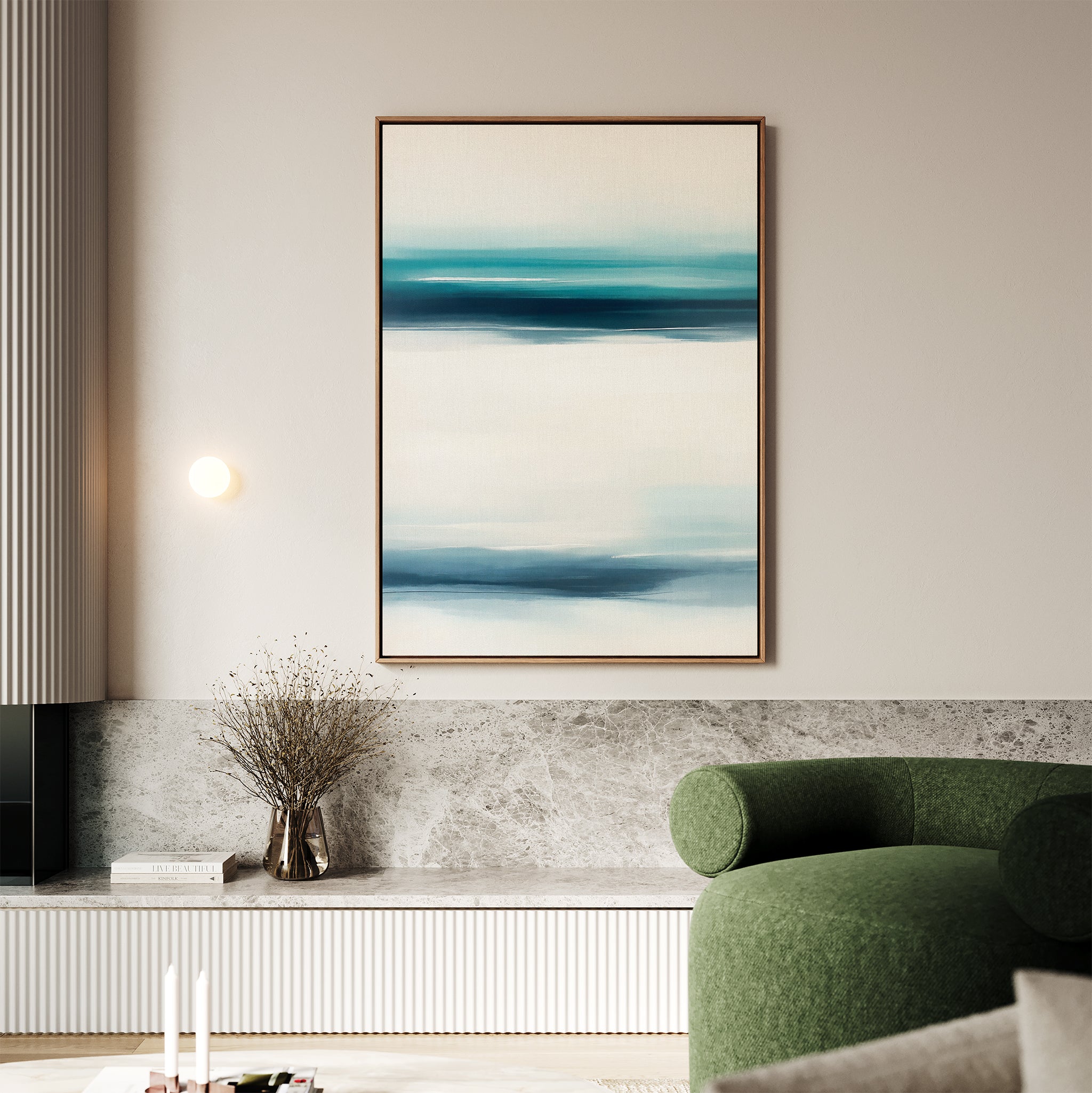 A modern living room with a green curved sofa, marble and wood console, coastal decor, dried branch vase, and the Ocean Motion Canvas Art - Vertical above soft lighting for serene sophistication.