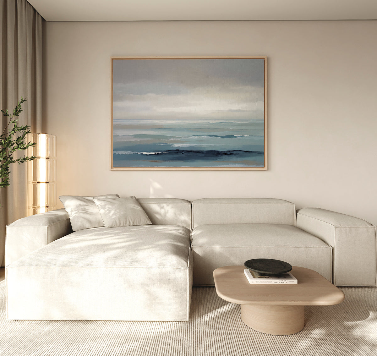 Minimalist living room featuring a light beige sectional, low wooden coffee table, potted plant, and Ocean Swells Canvas Art - Horizontal. Neutral tones and soft natural light contribute to a calm atmosphere.