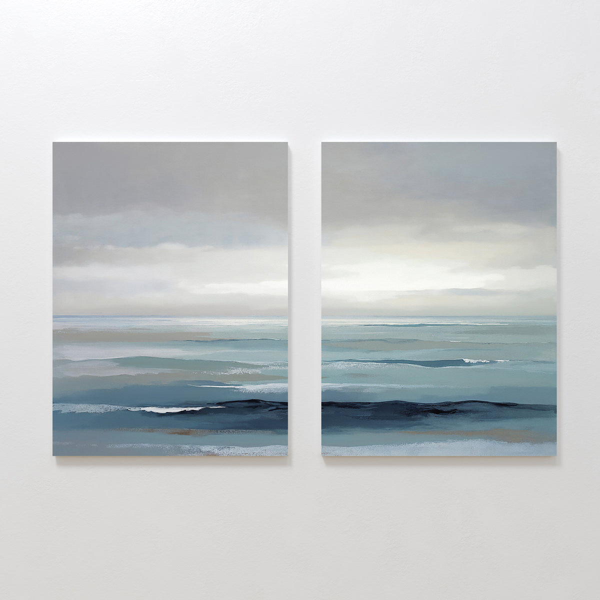Ocean Swells - Set Of 2 features serene coastal prints with calm blue-gray waters, gentle waves, and a cloudy sky, capturing peaceful Nordic Park-inspired wall art in soft, muted tones.