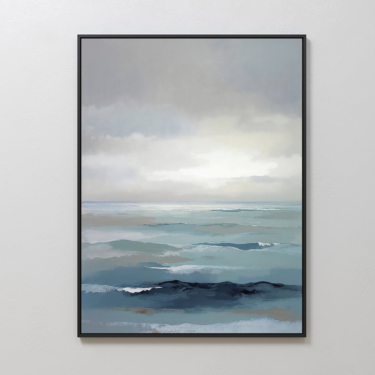 The Ocean Swells Canvas Art - Vertical features a framed coastal print of gentle ocean waves under a cloudy sky in soft blue, gray, and white, offering serene wall art that enhances any plain white wall.