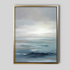Ocean Swells Canvas Art - Vertical features a calm ocean scene in soft blue and gray tones with gentle waves and a cloudy sky, framed in gold for a striking contrast against its light gray background, creating serene wall art.