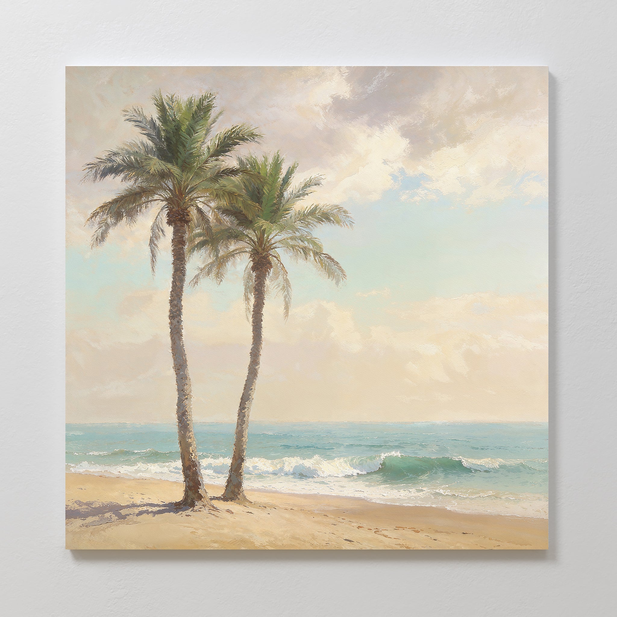 Paradise Found Canvas Art - Square features two tall palm trees on a sandy beach with gentle ocean waves and a partly cloudy sky, making it ideal as serene wall art or tropical décor for any space.