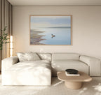 A modern living room with a light beige sectional, wooden coffee table, and the Peaceful Duck Haven Canvas Art - Horizontal above the sofa. Neutral tones and natural light capture Nordic Park’s calm in this tranquil space.