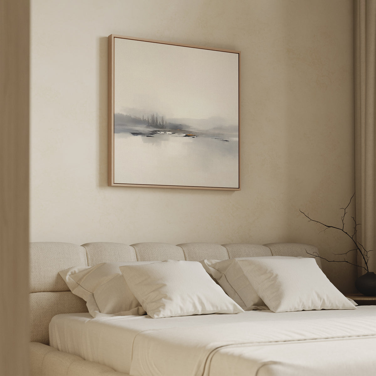 A minimalist bedroom features a light beige bed, white pillows, and a soft headboard. Above the bed hangs the Peaceful Lake Morning Canvas Art - Square, while a bare branch on the side table adds to the tranquil ambiance.
