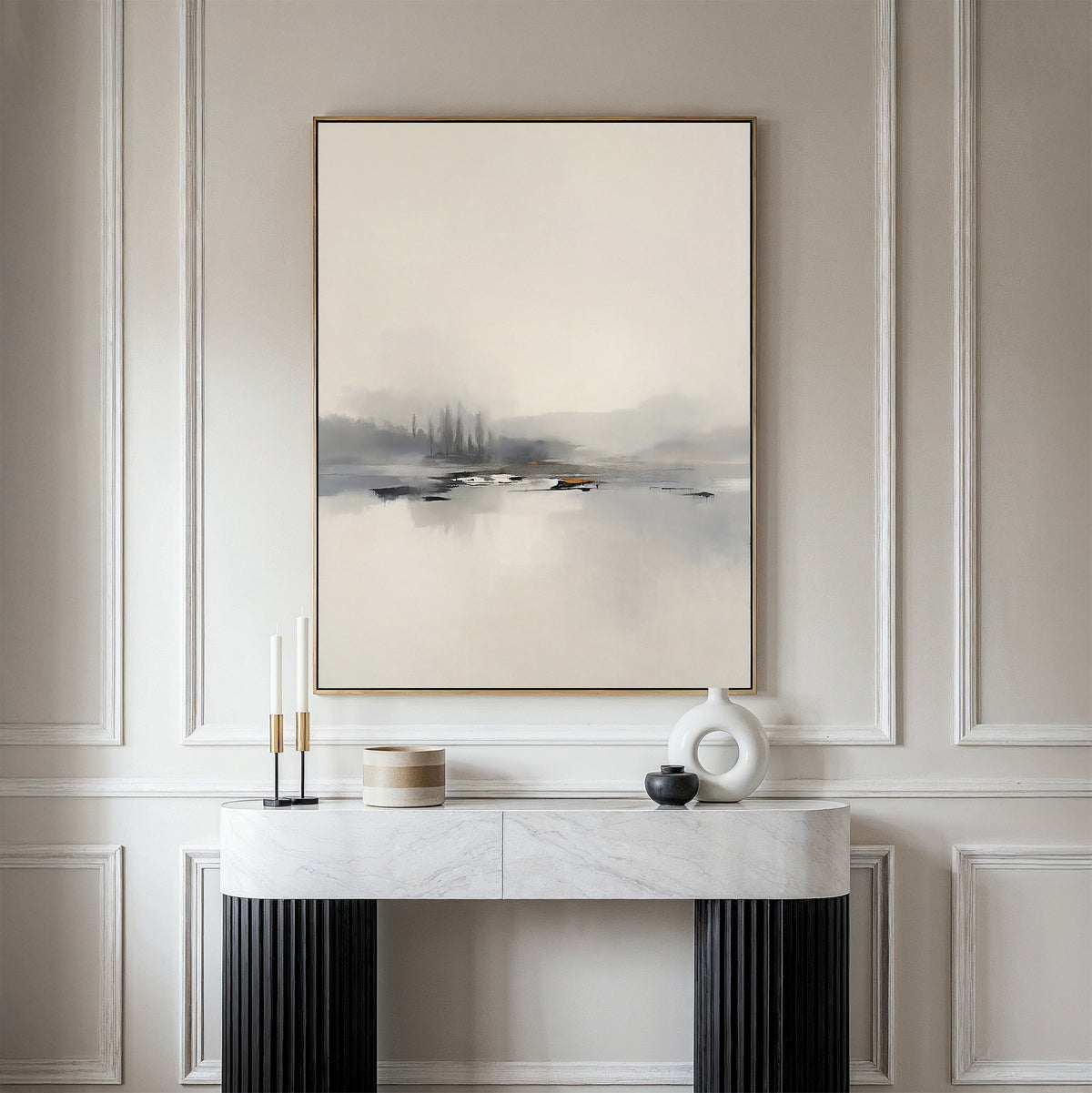 A minimalist room features the Peaceful Lake Morning Canvas Art - Vertical above a modern console table, decorated with candles, a white sculpture, and a small wooden container for a peaceful atmosphere.