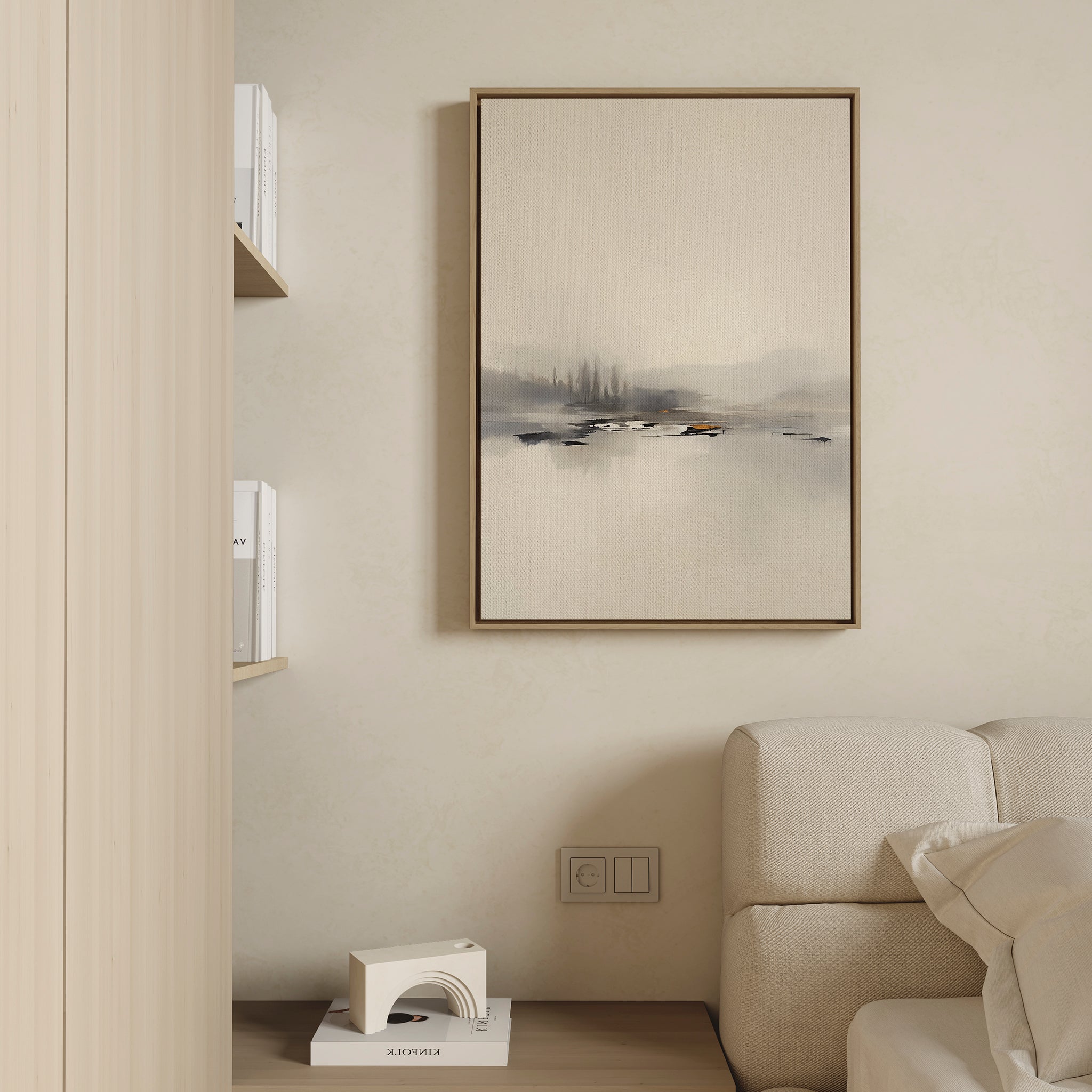 A minimalist living room with a beige sofa, built-in bookshelves, a modern white decor piece, and the Peaceful Lake Morning Canvas Art - Vertical adds a tranquil touch to the wall.