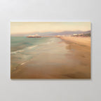 The Pier Dreams Canvas Art - Horizontal features a soft pastel scene of a sandy beach, gentle waves, a distant pier, and hazy mountains below a calm sky—ideal dreamy wall decor for creating serene and relaxing spaces.