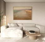 A modern living room features a light beige sectional, low wooden coffee table, potted plant, and neutral decor enhanced by the Pier Dreams Canvas Art - Horizontal, adding a dreamy coastal vibe to the minimalist space.
