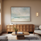 A cozy living room features a light sofa, wooden coffee table, textured sideboard, and the Serene Beach Canvas Art above. A small plant and books on the coffee table enhance the vintage decor charm.