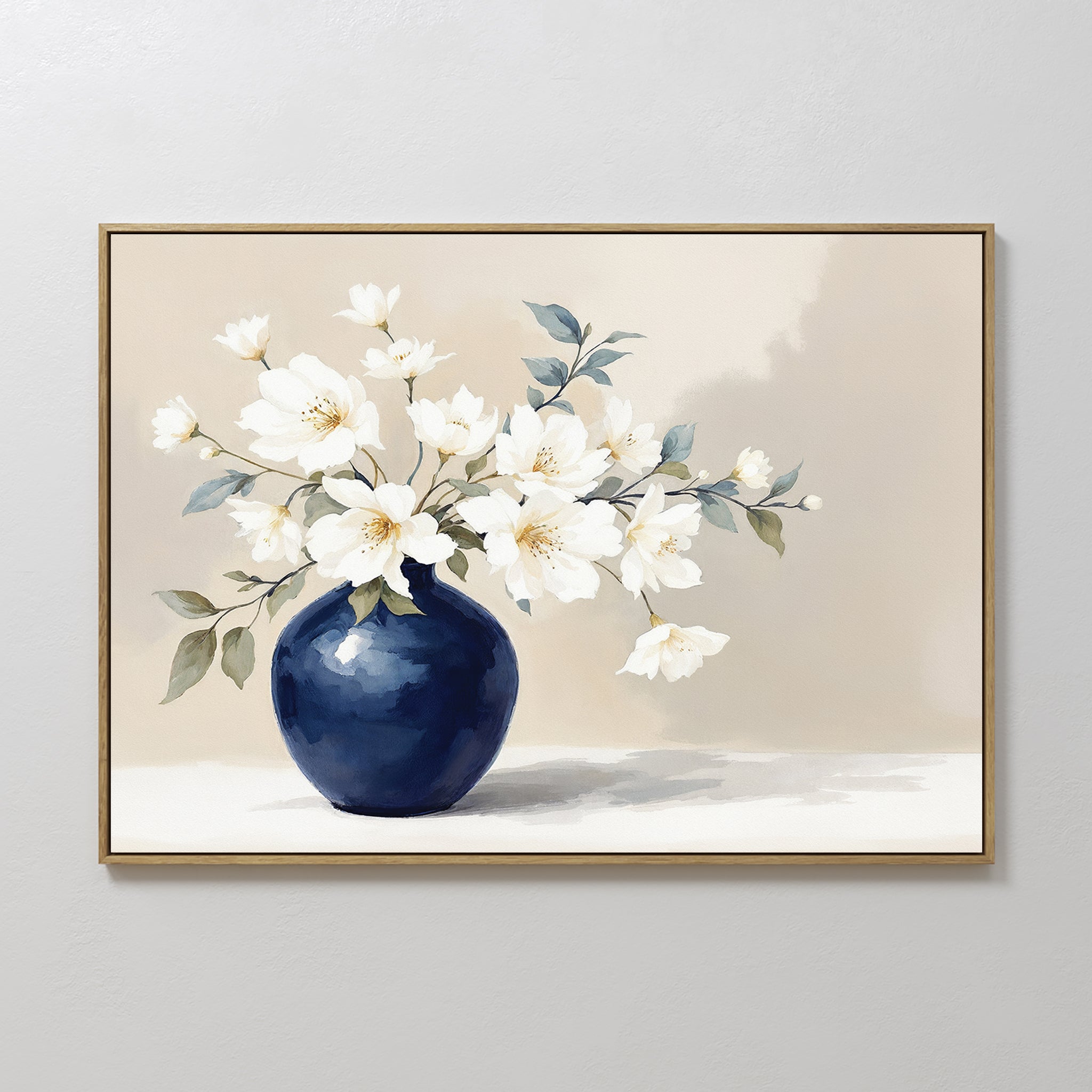 The Porcelain Dreams Canvas Art - Horizontal features white flowers with green leaves in a round blue vase on a beige background, beautifully framed and displayed on a light-colored wall.