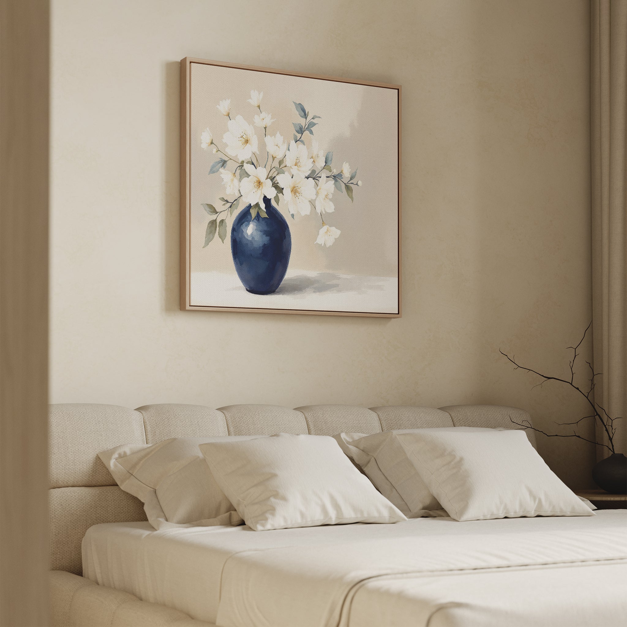 A minimalist bedroom with a beige upholstered bed, white pillows, and the Porcelain Dreams Canvas Art - Square, featuring white flowers in a navy blue vase above the headboard. Soft lighting and neutral tones create a calm atmosphere.