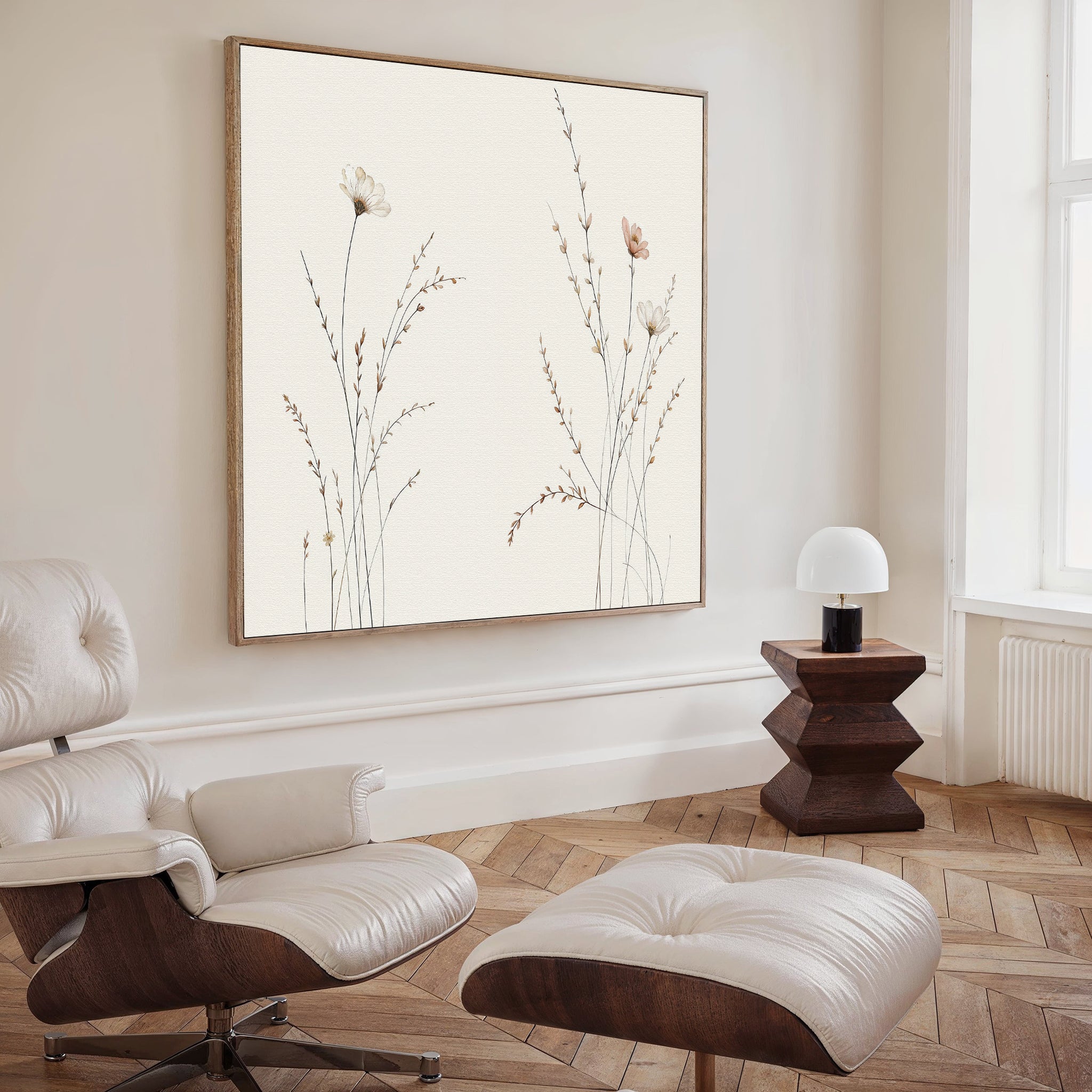 A modern minimalist living room with a white leather lounge chair and ottoman, dark wood side table with a white dome lamp, and striking Prairie Whispers Canvas Art - Square as botanical wall art on the wall.