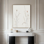 Minimalist interior with a marble console table, decorative objects, and the Prairie Whispers Canvas Art - Vertical featuring delicate botanical designs on a light background, set against light-paneled walls for natural tranquility.