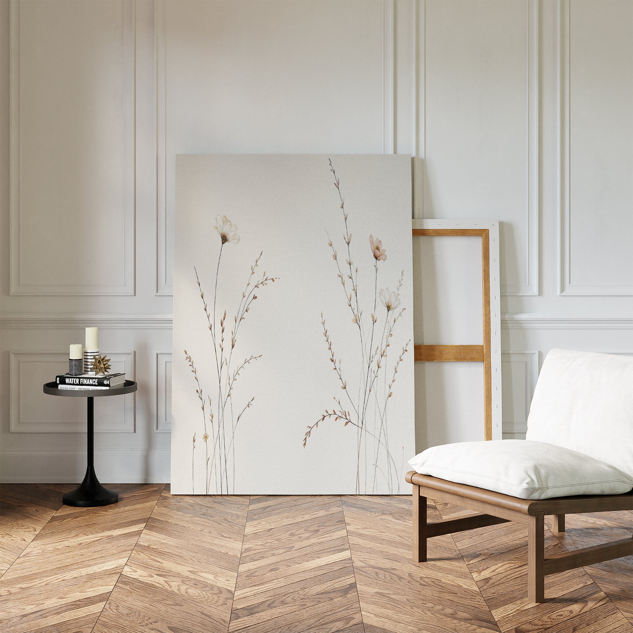 A minimal living room features a light wooden chair, side table with candles and books, and the Prairie Whispers Canvas Art - Vertical leaning against a white paneled wall on a herringbone floor, evoking natural tranquility.