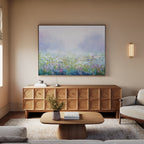 A minimalist living room featuring the Purple Haze Canvas Art - Horizontal, a wooden sideboard, coffee table with a small vase of flowers, sofa, and soft natural light—ideal for modern living room decor.