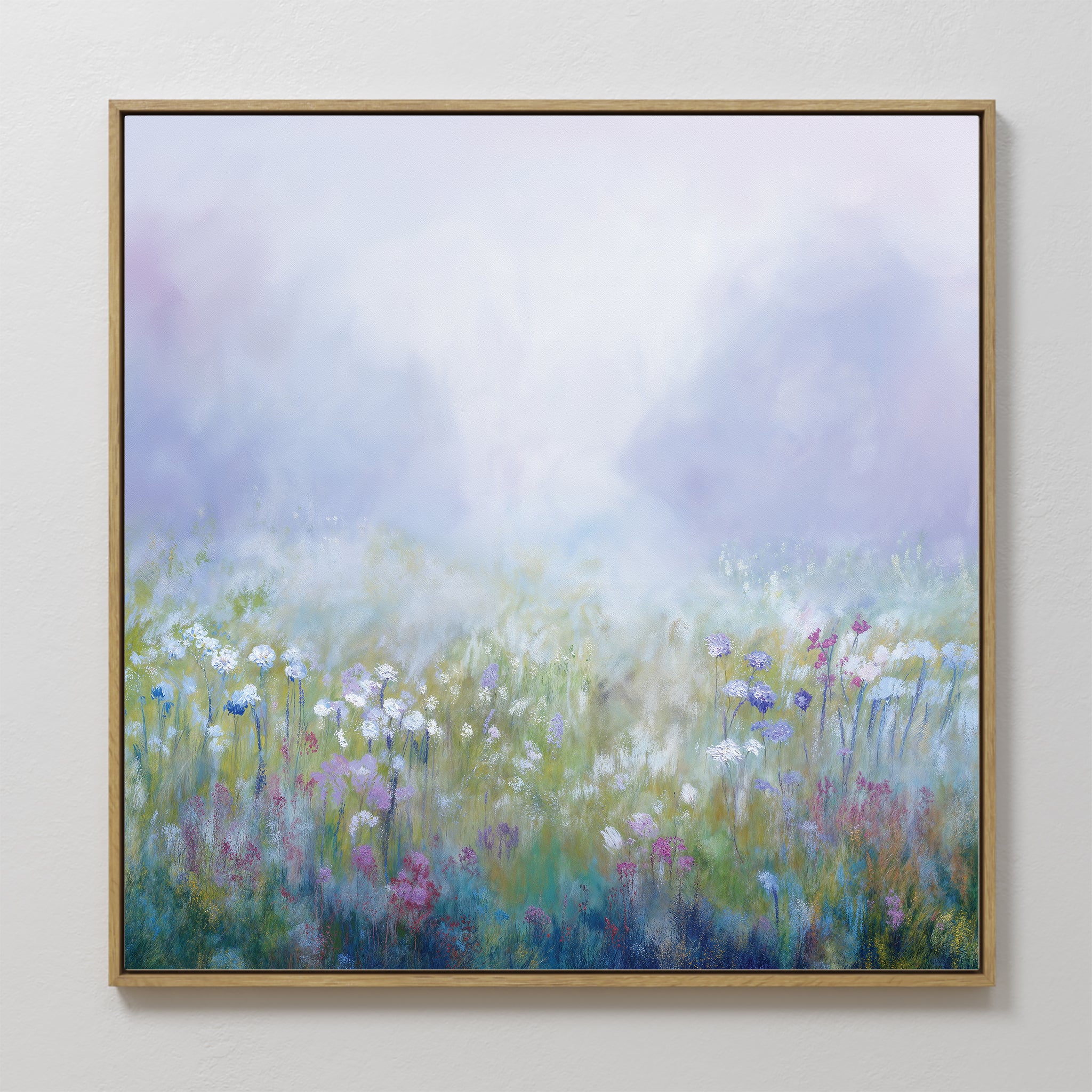 The Purple Haze Canvas Art - Square features a dreamy, framed print of a misty meadow with wildflowers in white, purple, pink, and blue. Soft, blurred tones create an ethereal look—ideal for bedroom or living room decor.
