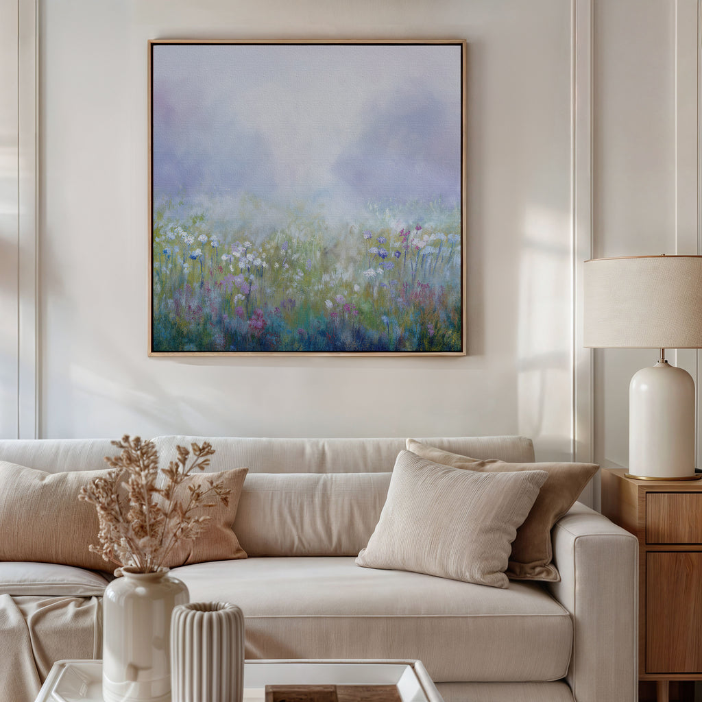 A cozy living room featuring a beige sofa with cushions, a lamp on a wooden side table, dried flowers in a vase, and the Purple Haze Canvas Art - Square—an ideal piece to add charm to your decor.