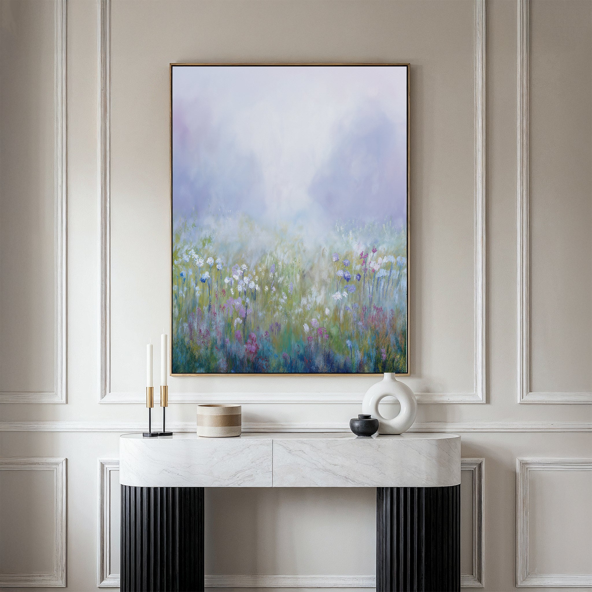 The "Purple Haze Canvas Art - Vertical" hangs on a light wall above a white console table with black legs, adding charm to your living room decor. Decorative items and candles sit on the table beneath this misty wildflower meadow print.