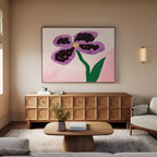 A modern living room with a light sofa, wooden coffee table, and sideboard features the Purple Pansy Canvas Art - Horizontal above the sideboard—a vivid botanical print of a purple-petaled flower with a green stem.