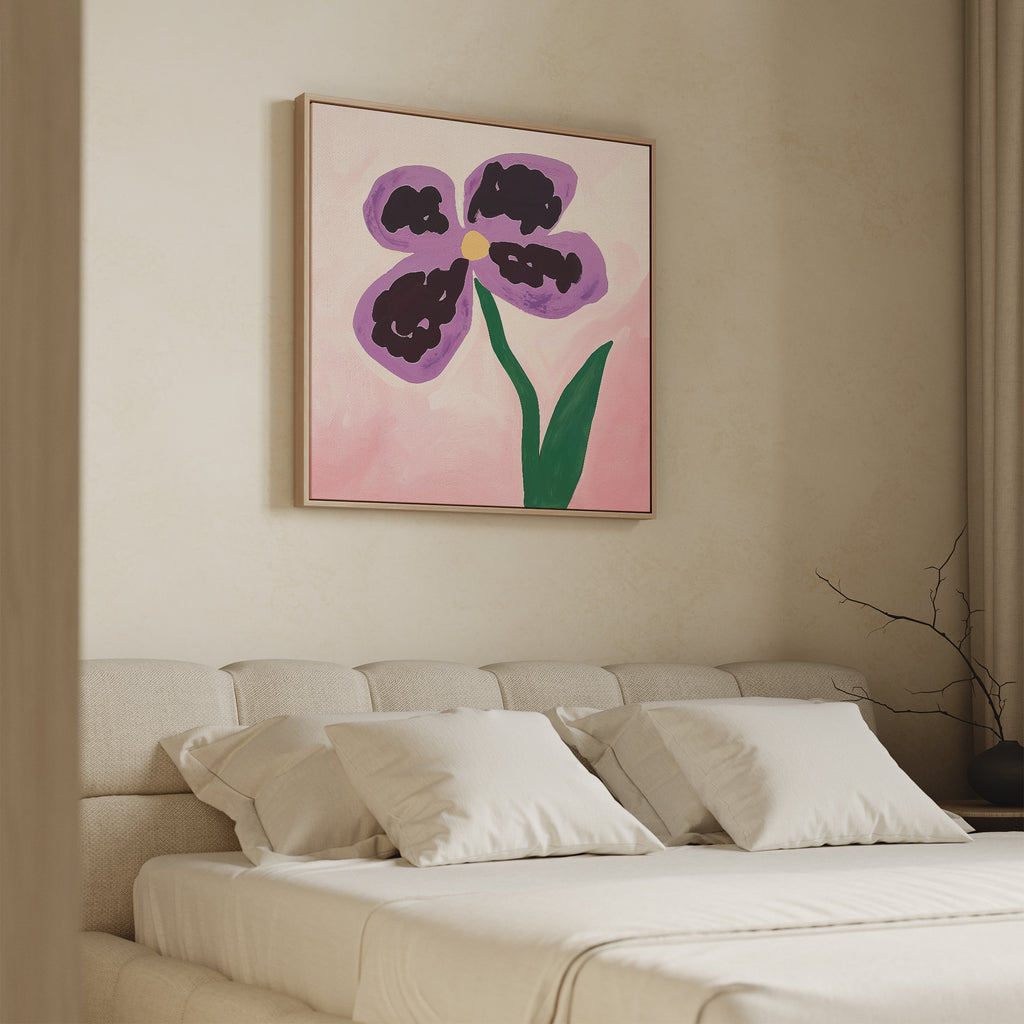 A minimalist bedroom features a beige bed, white pillows, and the Purple Pansy Canvas Art - Square above the headboard—its large purple pansy with green stem on pink adds a Nordic Park-inspired calm to the space.