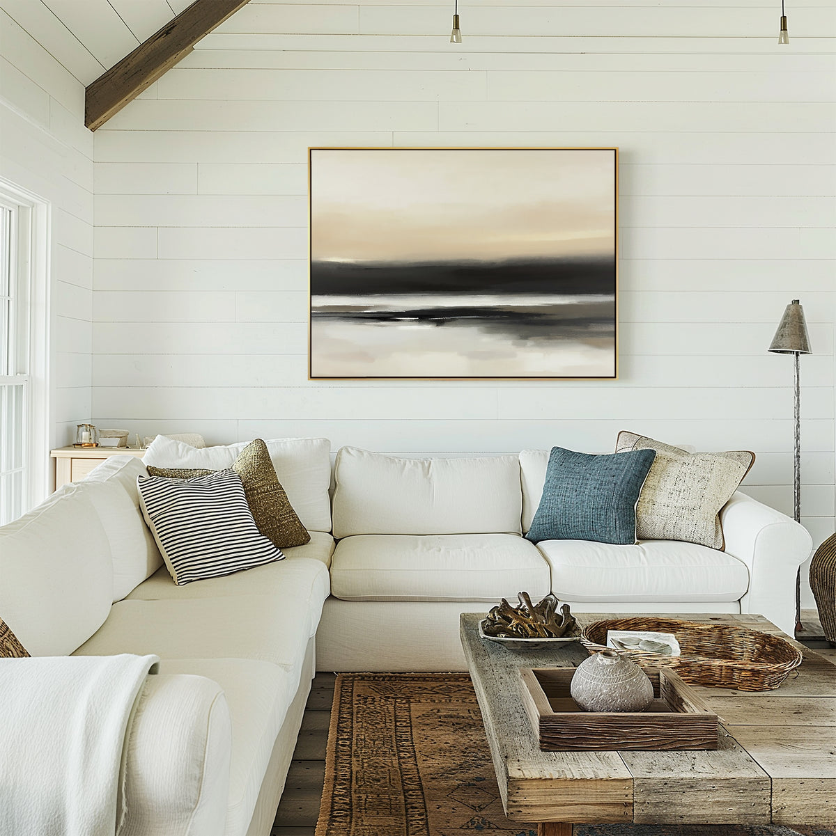 A cozy living room featuring a white sectional sofa with assorted pillows, a rustic wooden coffee table, and Quiet Shoreline Canvas Art - Horizontal displayed on white shiplap walls, plus a floor lamp in the corner.