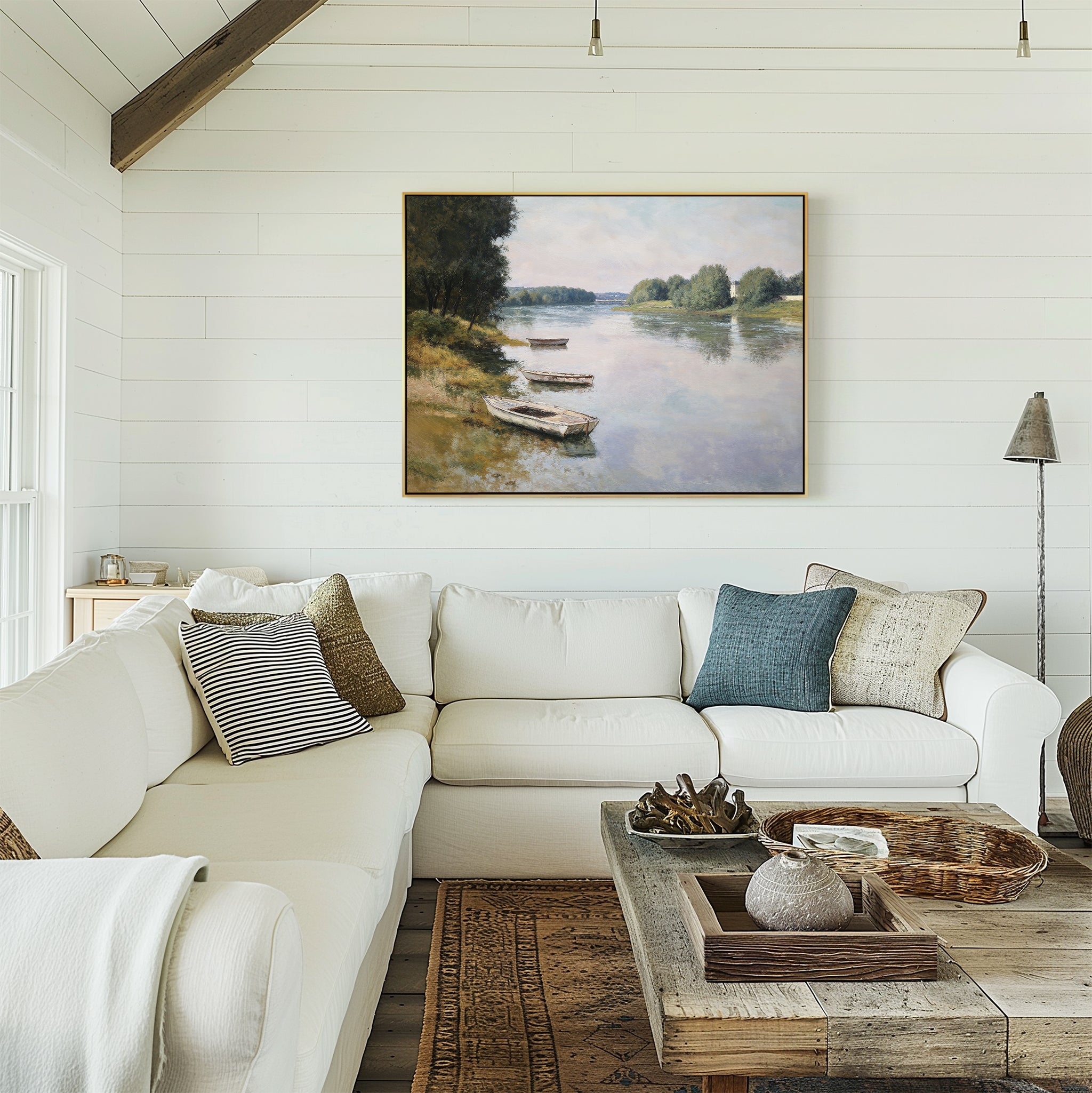 A bright, cozy living room with a white sectional, neutral pillows, a rustic wood coffee table, and the "River Tranquil Canvas Art - Horizontal" as serene wall décor on classic white shiplap walls.