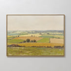 The Rolling Fields Canvas Art - Horizontal features a pastoral countryside landscape of rolling hills, green and yellow fields, scattered trees, and a cloudy sky, displayed on a plain white wall.