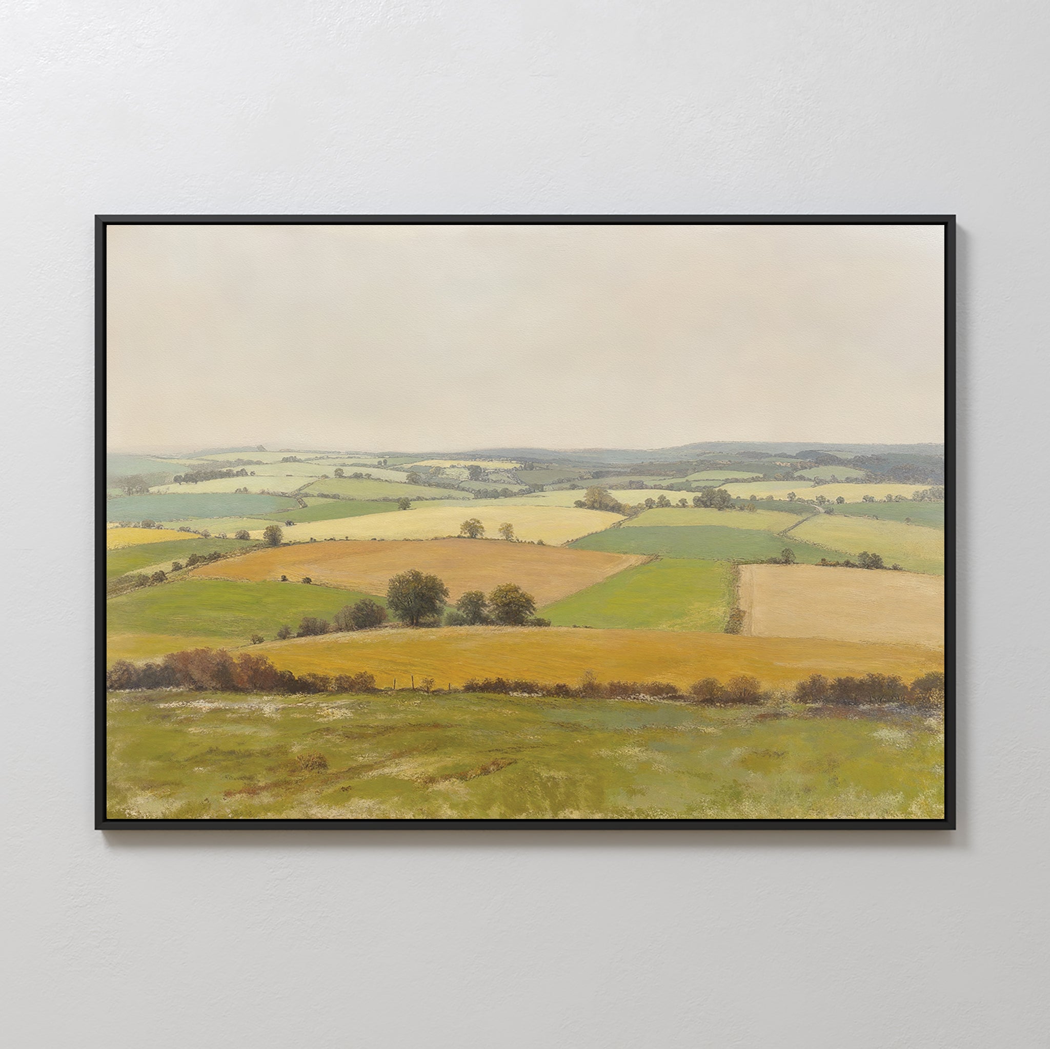 The Rolling Fields Canvas Art - Horizontal features a pastoral countryside landscape with green and yellow fields, hedgerows, and trees beneath an overcast sky, offering serene wall art for any light-colored space.
