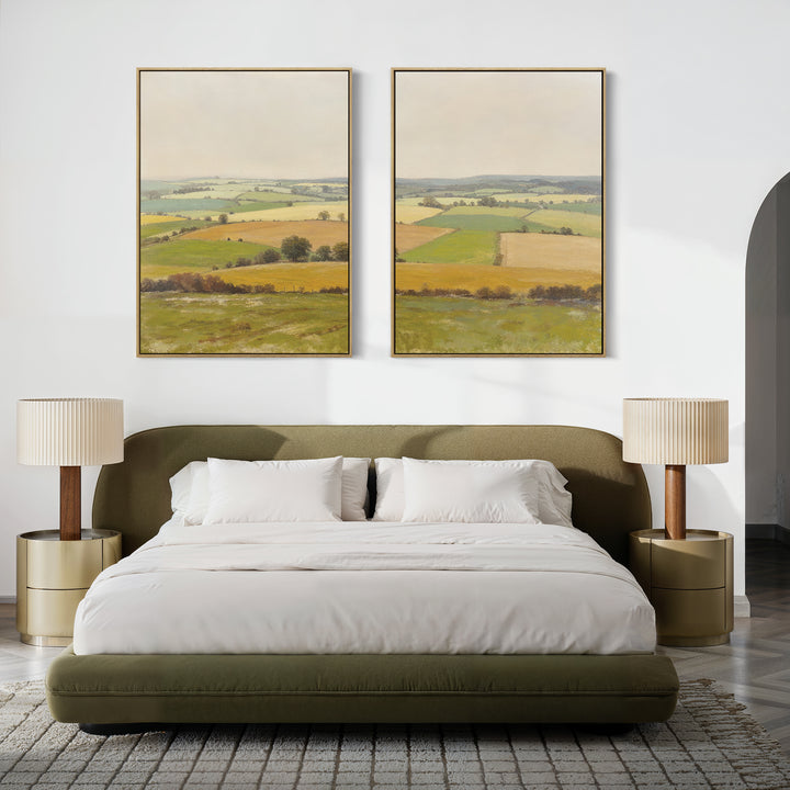 A modern bedroom features a green upholstered bed, white bedding, beige nightstands with matching lamps, and "Rolling Fields - Set of 2" wall art above the bed, showcasing tranquil pastoral countryside scenes in elegant frames.