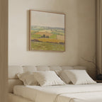 A cozy bedroom features a beige bed with white pillows and the Rolling Fields Canvas Art - Square, displaying soft green and yellow field scenes above the headboard. A simple vase with bare branches rests on the side table.
