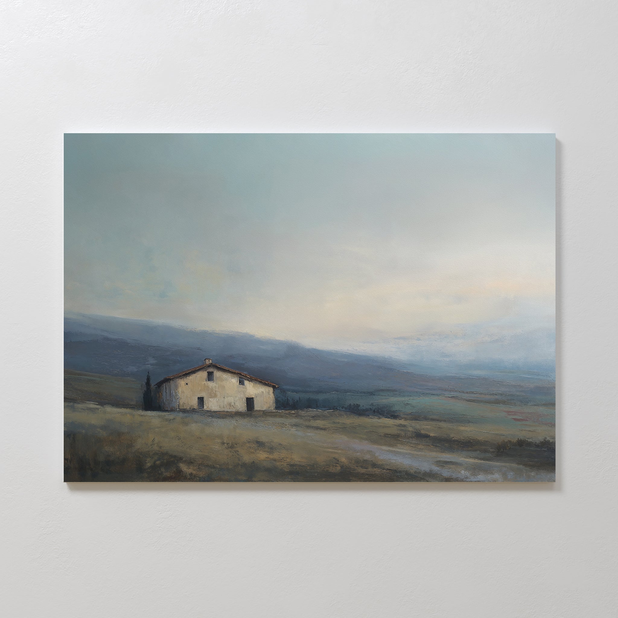 Rustic Solitude Canvas Art - Horizontal features a solitary farmhouse set amid gentle, grassy hills beneath a cloudy sky. Muted colors and an open landscape evoke calm and serenity, making it ideal decor for tranquil spaces.