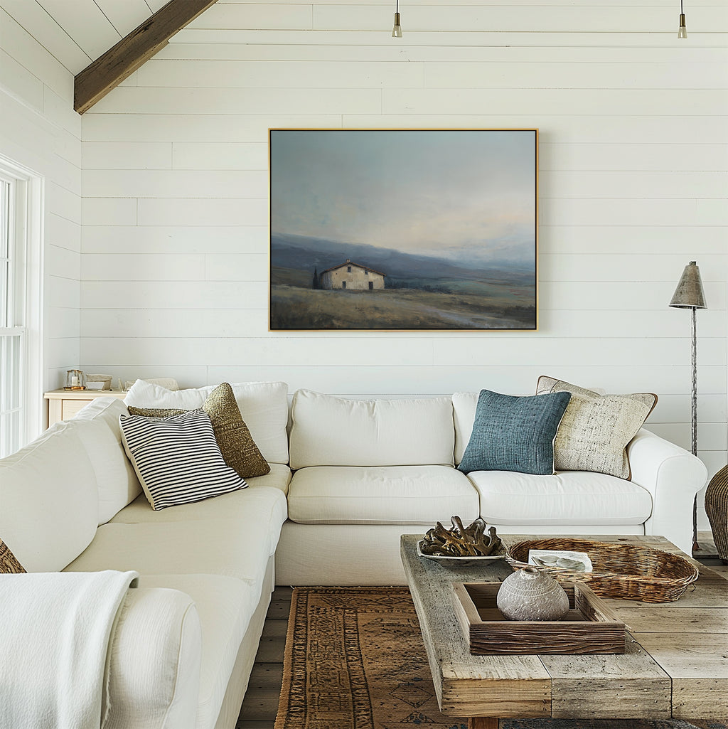 A bright, cozy living room features a white sectional sofa, assorted pillows, a rustic wooden coffee table, and serene decor with the Rustic Solitude Canvas Art - Horizontal on the white shiplap wall.