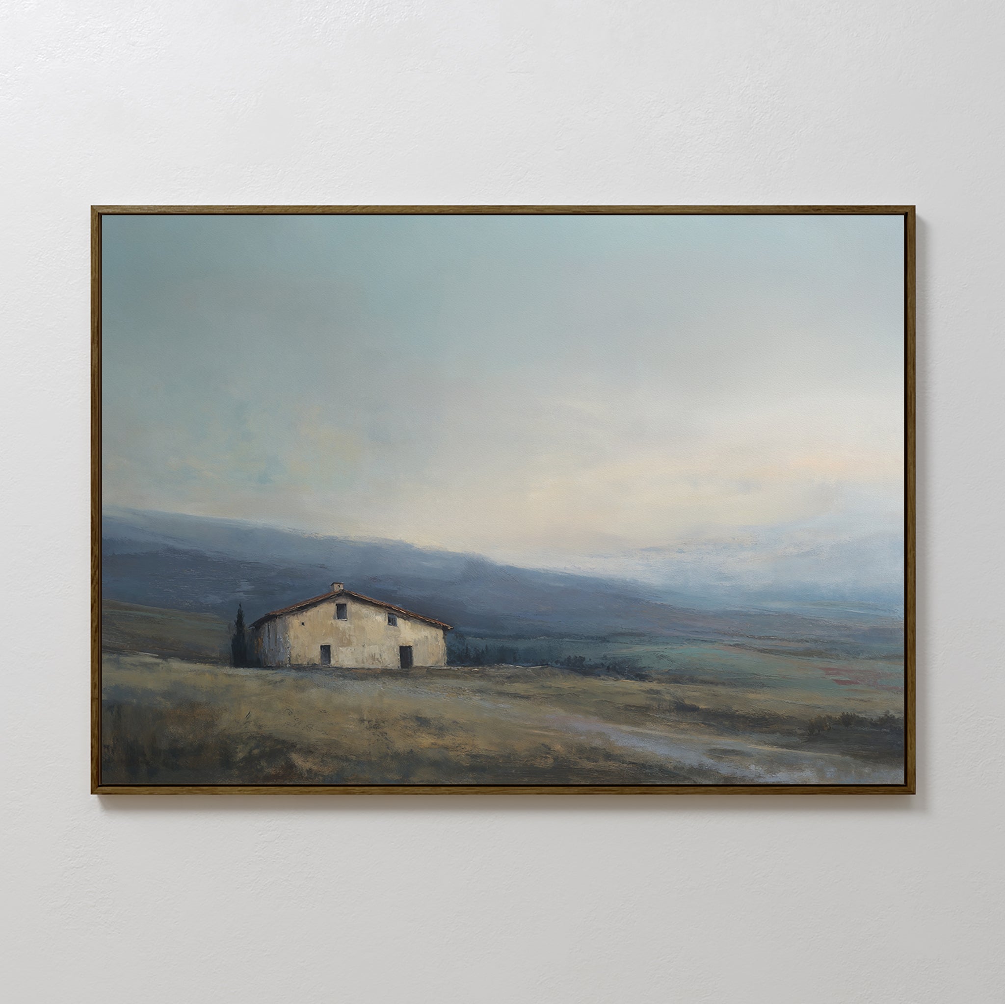 The Rustic Solitude Canvas Art - Horizontal features a solitary house on an open field with hazy mountains and a cloudy sky, adding serene landscape decor to your white wall.