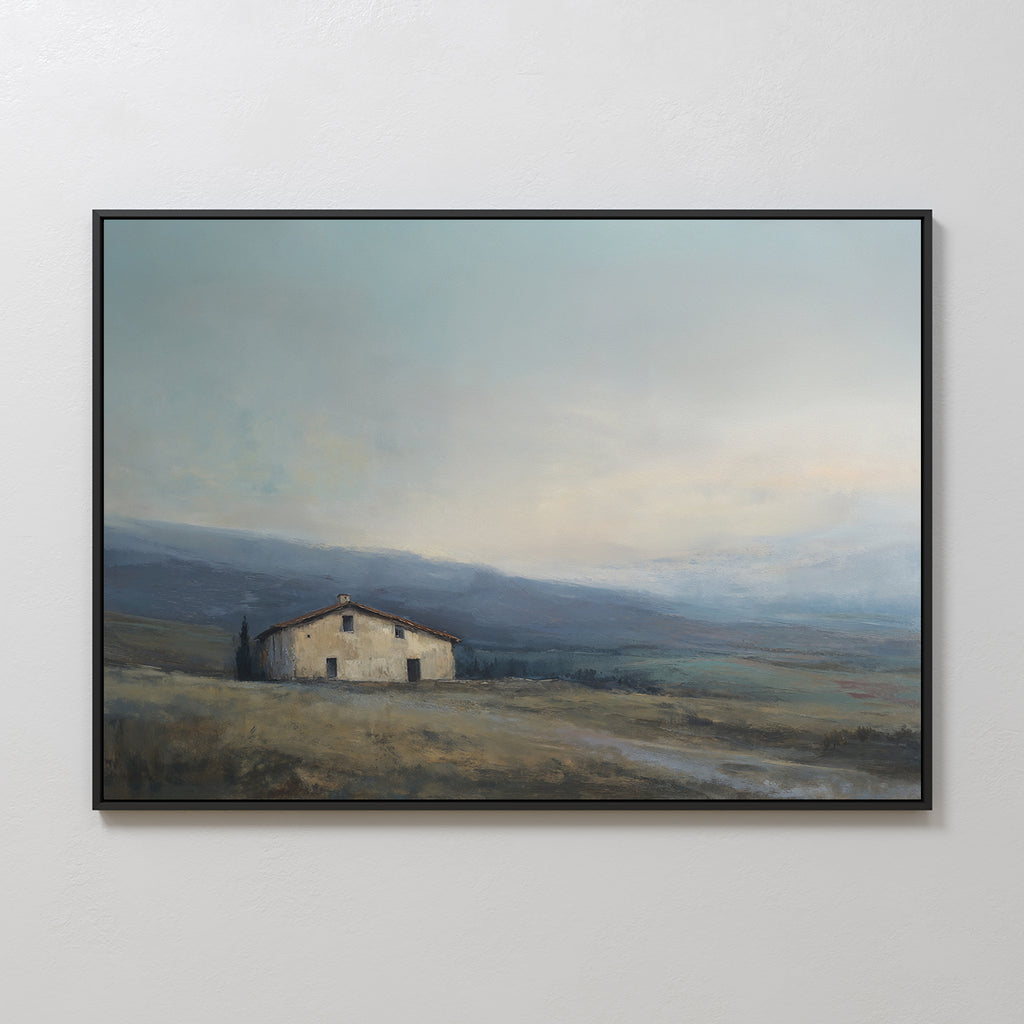 The Rustic Solitude Canvas Art - Horizontal features a framed print of a solitary house in an open countryside, set against cloudy skies and distant hills, with earth-toned colors for a calm, serene feel.