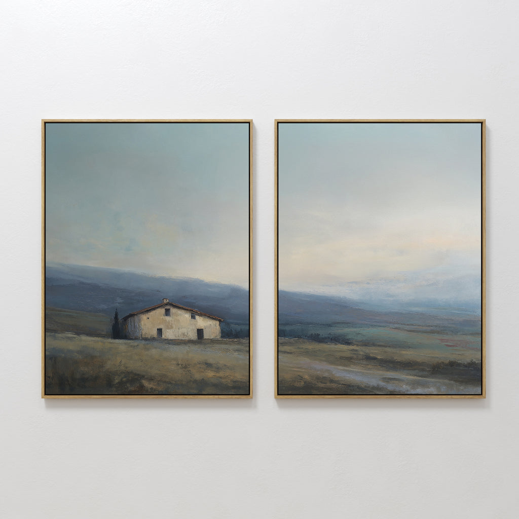The "Rustic Solitude - Set of 2" features framed landscape wall art: one print depicts a rustic farmhouse in open fields with distant hills, while the other continues the serene décor with wide skies and rolling terrain.