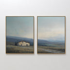 The "Rustic Solitude - Set of 2" features framed landscape wall art: one print depicts a rustic farmhouse in open fields with distant hills, while the other continues the serene décor with wide skies and rolling terrain.