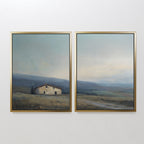 The Rustic Solitude - Set of 2 features framed wall art: one print shows a farmhouse in an open field, the other depicts tranquil mountains under a soft, muted sky—perfect for adding serene landscape decor to any room.