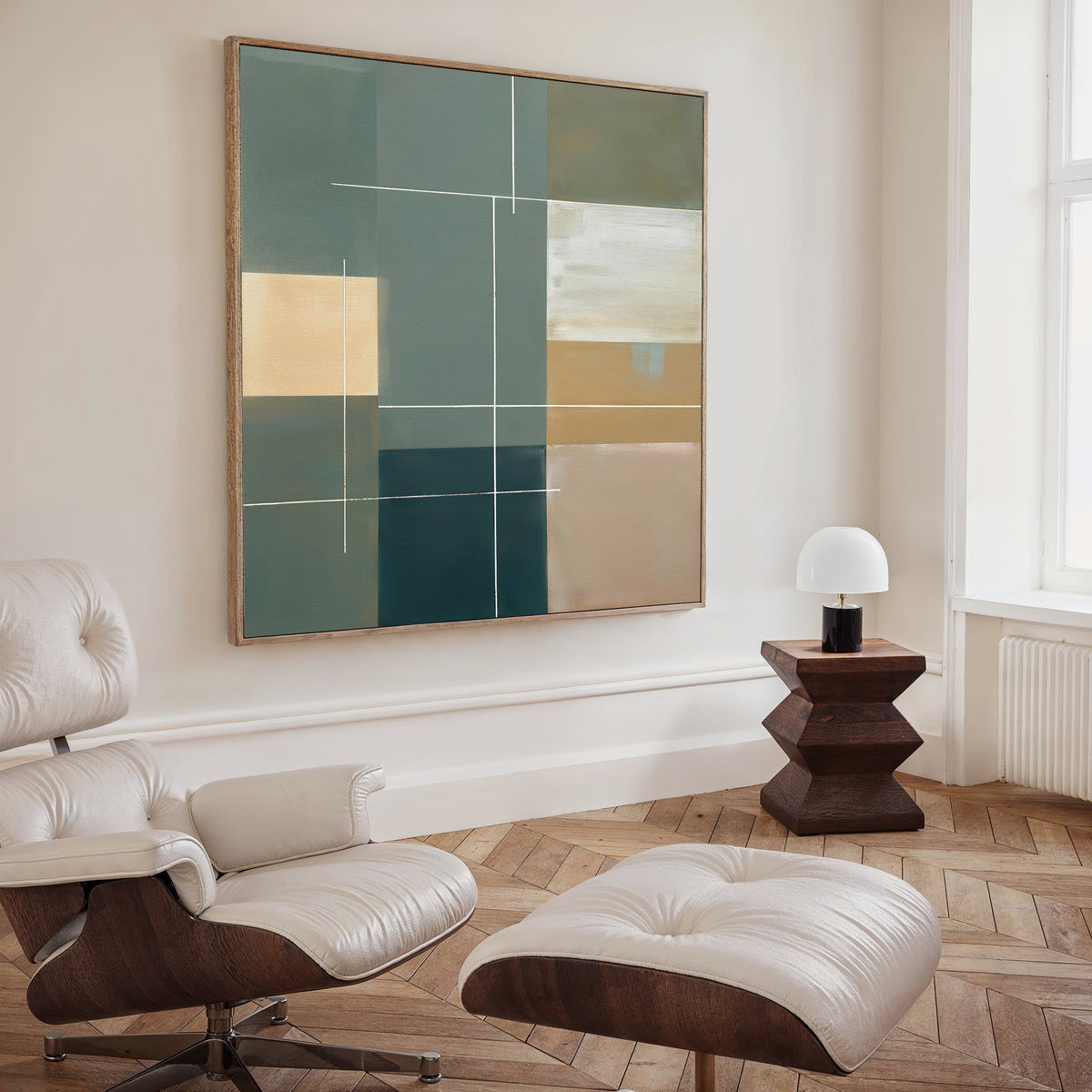 A modern living room with a cream Eames lounge chair and ottoman, light herringbone wood floors, a small wooden side table, white glass lamp, and Sage Compartments Canvas Art - Square displayed on the wall.