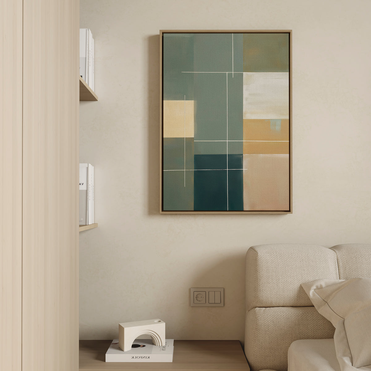 A minimalist living room corner featuring a beige sofa, a small shelf with books and decor, and the Sage Compartments Canvas Art - Vertical as modern wall art in muted green, tan, and cream tones.