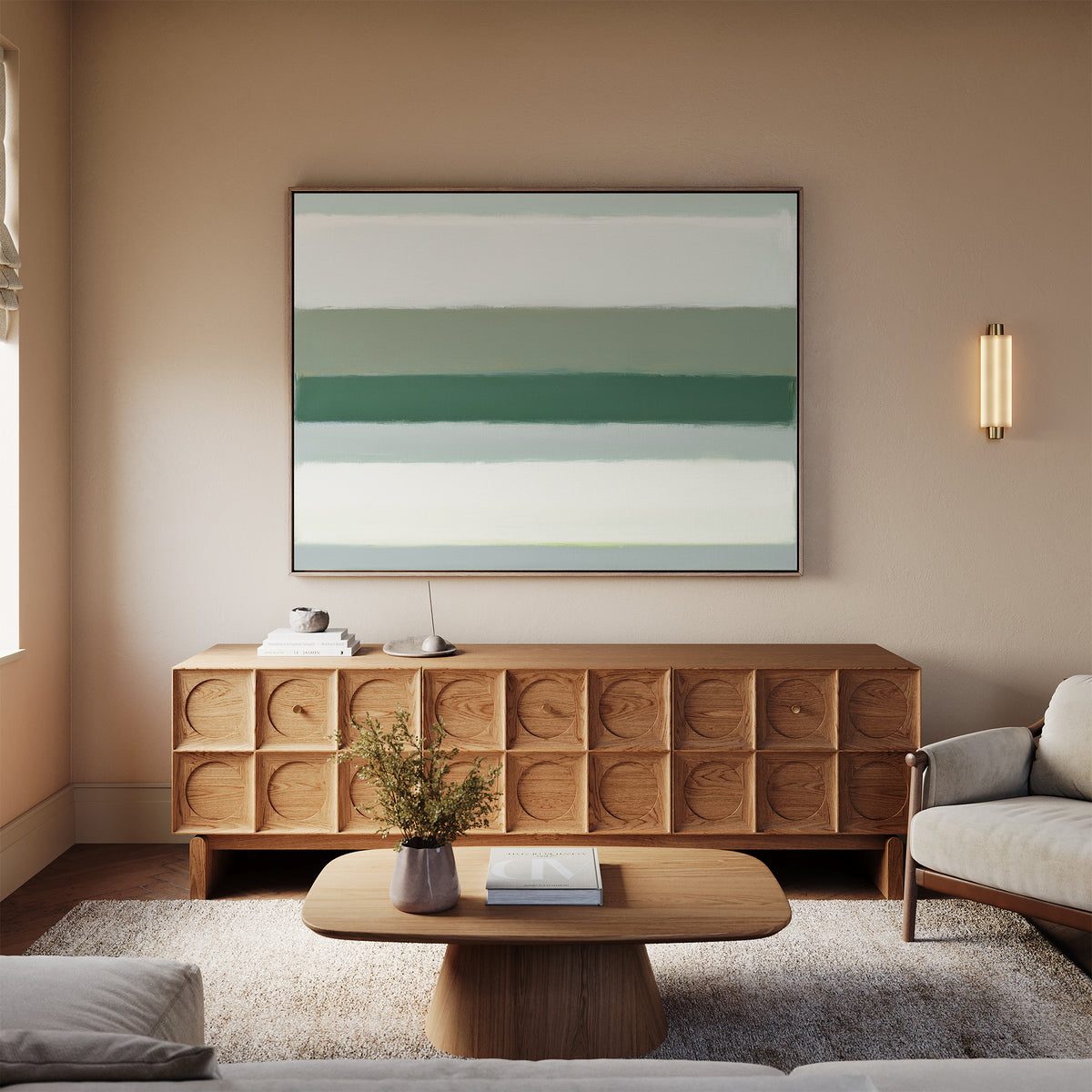 A cozy living room features a light sofa, wooden coffee table, and textured wooden sideboard. Above the sideboard hangs the Sage Gradient Canvas Art - Horizontal, showcasing abstract green and white stripes. A soft rug covers the floor.